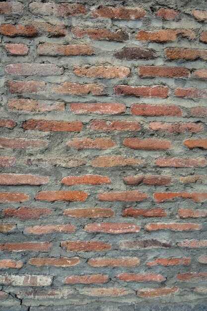 Fondo rojo de textura de pared de ladrillo antiguo vintage. Vista de cerca de la vieja pared de ladrillos de piedra con mampostería medieval. Foto de alta calidad