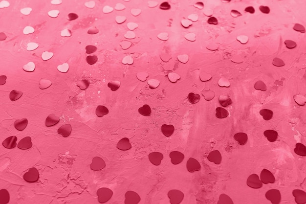 Foto fondo romántico del día de san valentín con corazones de aluminio en el color de moda del año 2023 viva magenta