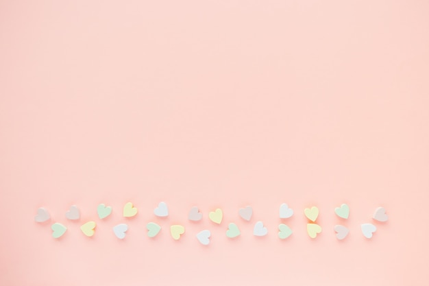 Fondo romántico rosa pastel con decoración de corazones