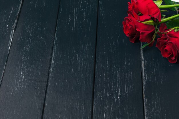 Fondo romántico con rosa roja en la mesa de madera