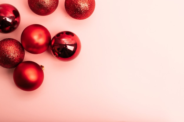 Fondo rosa enmarcado con bolas rojas de Navidad