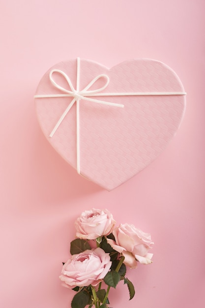 fondo rosa con flores y caja de regalo