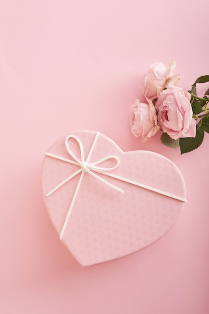 fondo rosa con flores y caja de regalo