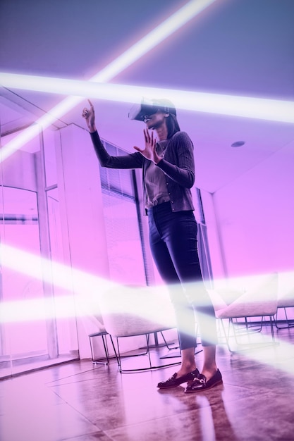 Fondo rosa y morado contra una ejecutiva que usa auriculares de realidad virtual
