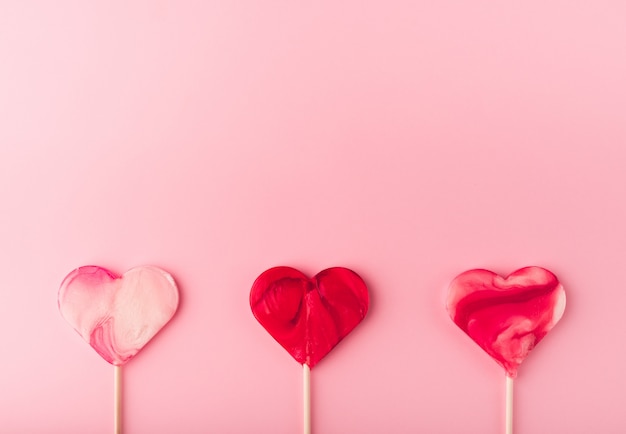 Fondo rosa vacaciones románticas con dulces en forma de corazón. Tarjeta decorativa para el día de San Valentín con espacio para texto. Canción de amor.