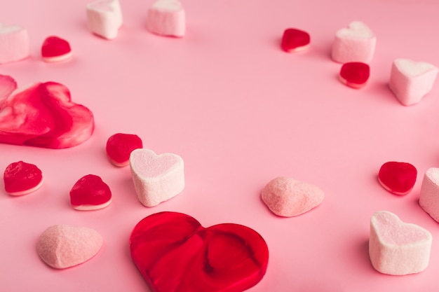 Fondo rosa vacaciones románticas con dulces en forma de corazón. Tarjeta decorativa para el día de San Valentín con espacio para texto. Canción de amor.