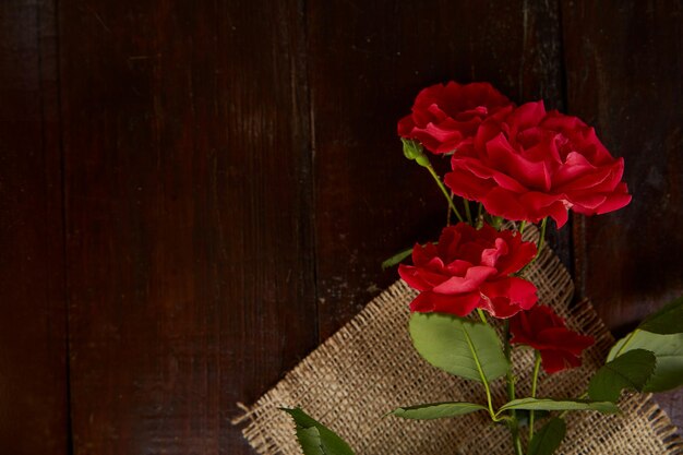 Fondo de rosas rojas en el saqueo sobre fondo de madera Regalo presente Espacio de copia