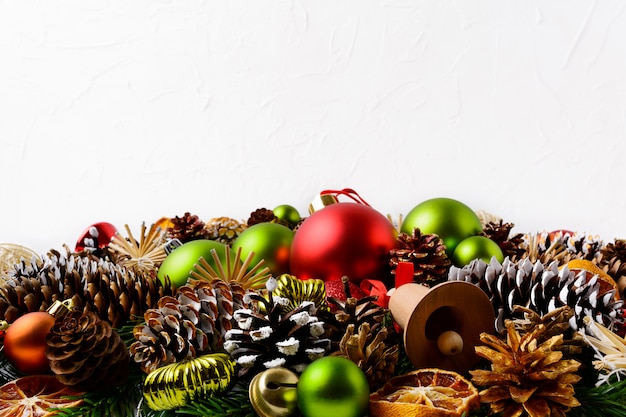 Fondo de saludo de Navidad con piñas decoradas a mano