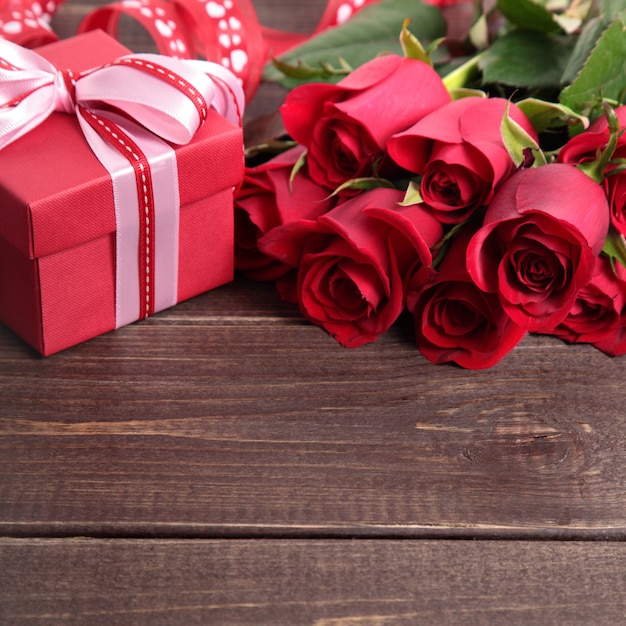 Foto fondo de san valentín de caja de regalo y rosas rojas en madera