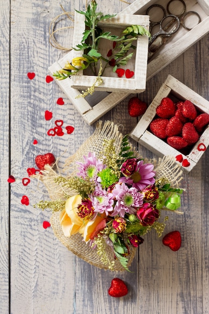 Fondo de San Valentín o boda. Cesta ramo de rosas y crisantemos.