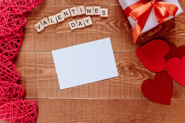 Foto fondo de san valentín con regalo de tarjeta de felicitación en blanco y corazón