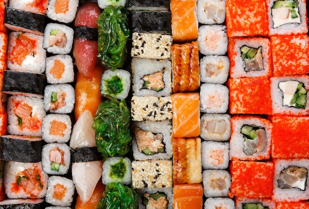 Fondo de sushi y rollos, vista superior de entrega de restaurante japonés. Salmón, unagi, california y otras coloridas comidas saludables