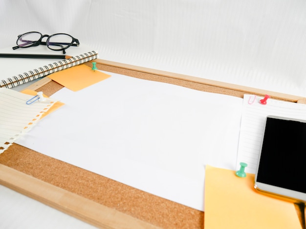 Fondo de una tabla de madera, papel de carta, papel en blanco con equipo alrededor, como lápices, anteojos, dinero, teléfonos móviles y calendarios,