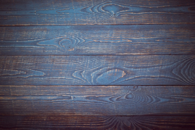 Fondo de tableros de textura de madera con restos de pintura azul y violeta. Viñeteado