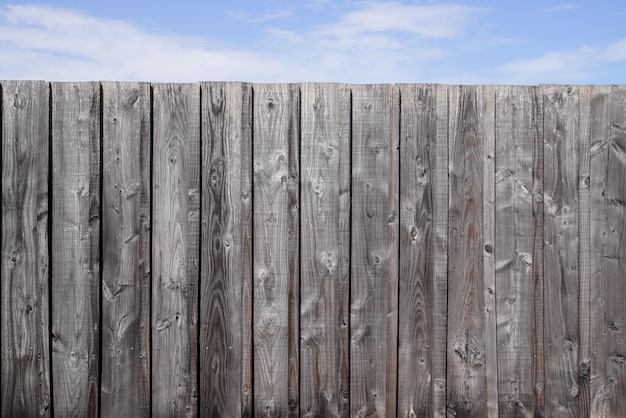 Fondo de tablón de cerca de pared de madera y cielo nublado para papel tapiz