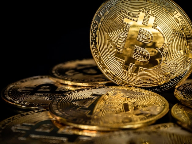 Fondo de tecnología Bitcoin. Bitcoin dorado brillante de primer plano sobre fondo oscuro con espacio de copia. Concepto de inversión en criptomonedas. Fondo financiero de la moneda de la moneda del futuro digital.