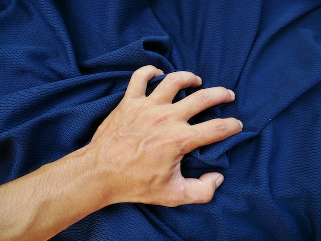 Fondo de tela de seda azul y mano de mujer