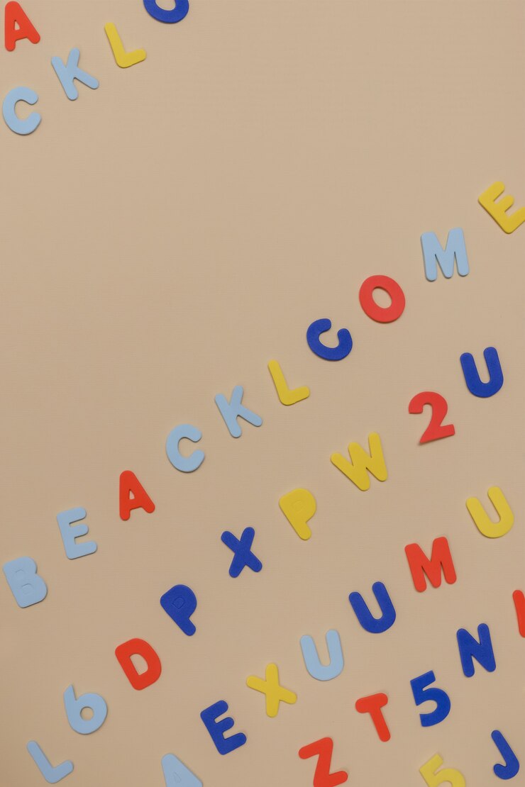 Foto fondo de tema escolar hecho de letras de espuma de colores naranja, amarillo y azul de una manera caótica sobre un fondo de papel beige. volver a la escuela creativa vista plana, superior con espacio de copia.