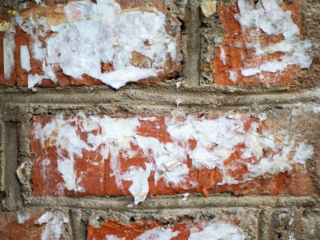 Fondo de textura abstracta Pared de ladrillo con ladrillos a la vista y viejo cartel de calle rasgado Elemento de diseño