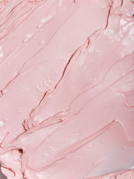 Fondo de textura de crema de belleza color rosa crema facial loción humectante frotis cosmético para el cuidado de la piel