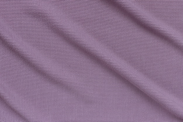 Fondo de textura de pana acanalada lila con suaves pliegues en la superficie.