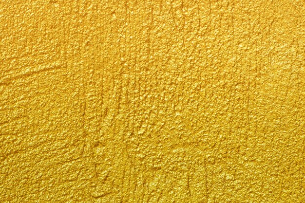 Fondo de textura de pared dorada Pintura de lámina dorada brillante amarilla en la superficie de la pared con reflejo de luz