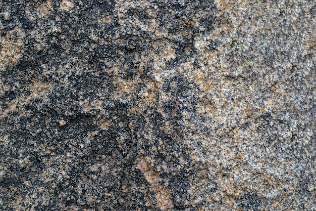 Foto fondo de textura de roca de granito gris crudo fragmento de muro de piedra natural