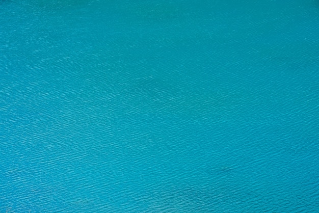 Fondo texturizado asombroso de la superficie azul tranquila del agua limpia.