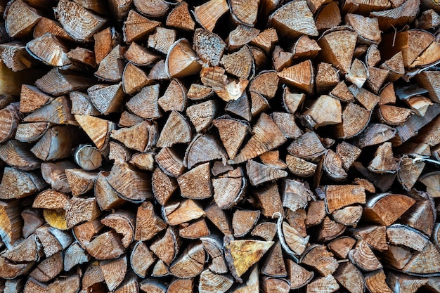 Foto el fondo de los troncos de madera cortados apilados, pila de troncos de leña listos para el invierno, tallos de madera, leña.