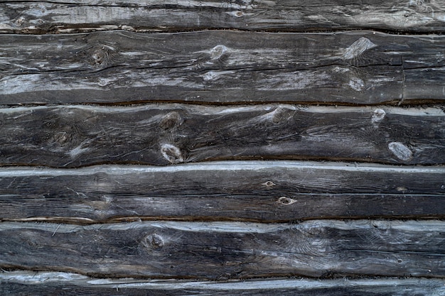 Fondo de troncos viejos negros La pared de una casa de madera vieja