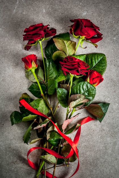 Fondo de vacaciones, día de San Valentín. Ramo de rosas rojas, corbata con una cinta roja