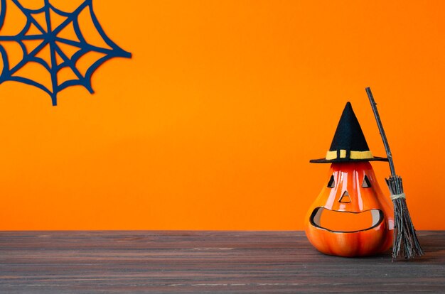 Fondo de vacaciones de Halloween con linternas de calabaza, escoba de calabaza y sombrero de bruja en mesa de madera