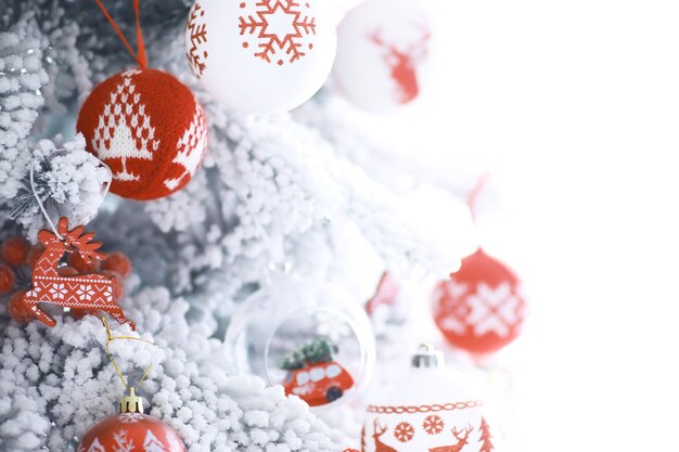 Fondo de vacaciones de Navidad. Adorno de plata y color colgando de un árbol decorado con bokeh y nieve, copie el espacio.