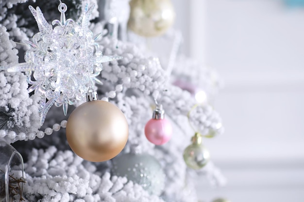 Fondo de vacaciones de Navidad. Adorno de plata y color colgando de un árbol decorado con bokeh y nieve, copie el espacio.