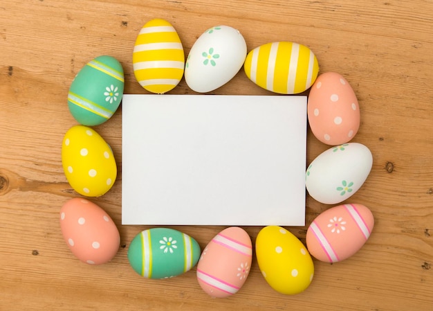 Fondo de vacaciones de Pascua Huevos de Pascua decorados en colores pastel con una etiqueta blanca en blanco sobre un fondo de madera