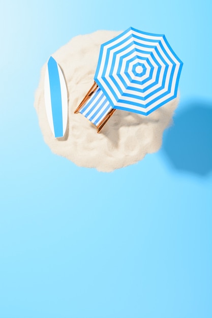 Foto fondo de vacaciones tropicales. tumbona con sombrilla y accesorios de playa para un descanso activo en la isla de arena, espacio de copia, vista superior