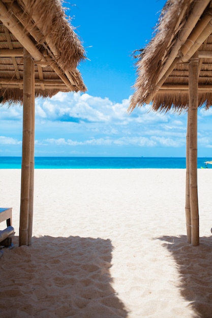 Fondo de vacaciones de vacaciones - tumbonas de playa sin gente en la soleada playa tropical con arena blanca
