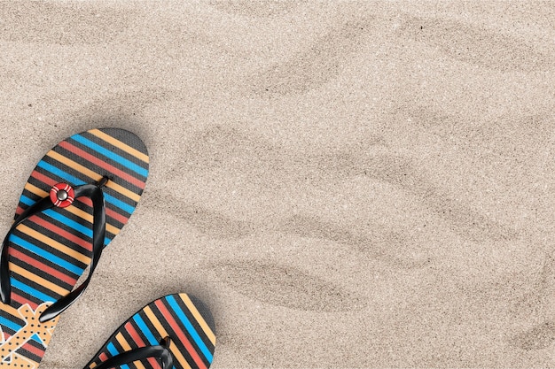 Fondo de vacaciones de verano con un par de chanclas en la playa