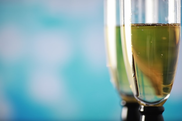 Fondo con vasos altos para vinos espumosos. Champán y spray en vasos de cristal. Bebida de celebración con reflejo.