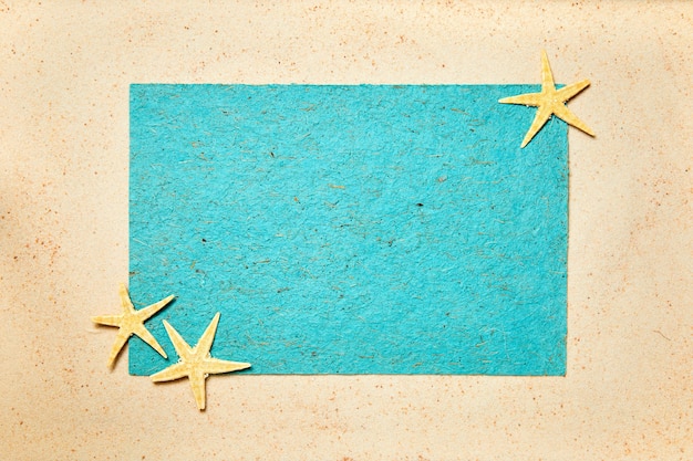 Foto fondo de verano de arena decorada con estrellas de mar y espacio de copia azul