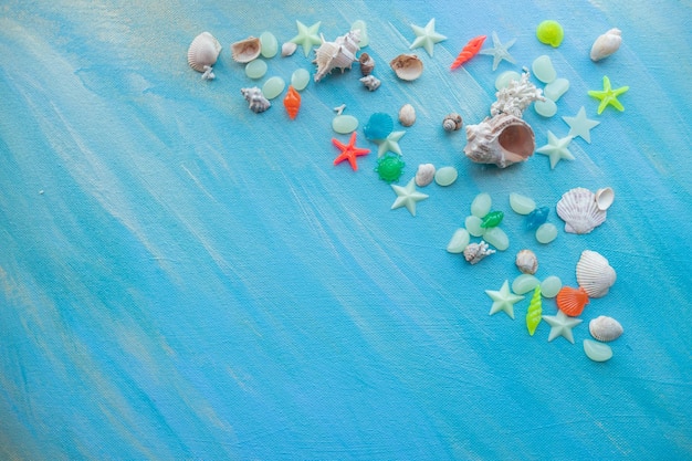 Fondo de verano de conchas marinas Muchas conchas marinas diferentes estrellas de mar sobre un fondo de trazos de pintura turquesa triángulo inferior izquierdo libre Lugar para texto
