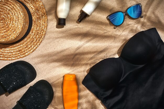 Fondo de verano con sombrero de paja, gafas de sol, botella de protección solar y chanclas