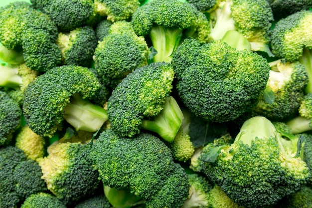 Fondo verde de brócoli fresco de cerca en la mesa de colores. Verduras para la dieta y la alimentación saludable. Alimentos orgánicos