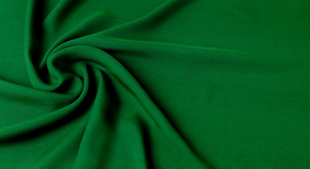 Fondo verde con una textura de tejido de algodón natural en ondas.
