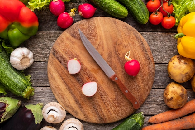 Fondo de verduras frescas con tabla de cortar y cuchillo. Vista superior