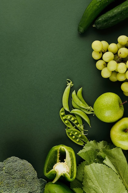 Foto fondo con verduras y frutas frescas en la superficie de la mesa verde, vista desde la parte superior