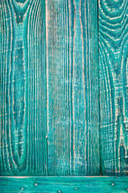 Fondo vertical de tres tableros de textura de madera verde sujetos por un tablón horizontal.