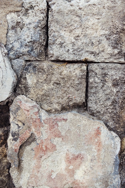 El fondo de una vieja pared de piedra agrietada