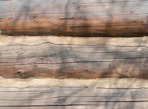Fondo de viejos troncos de madera Muro de una antigua casa rural de madera residencial Textura de madera