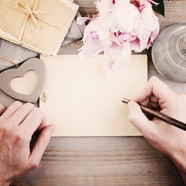 Fondo vintage con manos masculinas pluma y papel Hombre escribiendo carta de amor